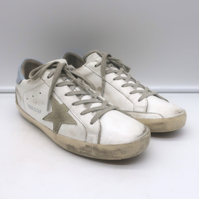 1) Golden Goose Superstar sneakers, white leather with blue accents, authentic pre-owned, good condition 2) Golden Goose white leather Superstar sneakers with blue star detail, authentic pre-owned women's shoes 3) Authentic pre-owned Golden Goose Superstar leather sneakers in white with blue trim, luxury casual wear
