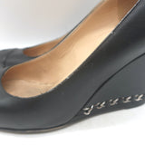 Chanel CC cap-toe chain-trimmed wedge pumps in black leather, pre-owned with authentic designer detailing, size 35.5