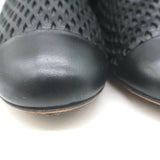 Authentic Chanel perforated cap-toe leather flat ankle boots in black, pre-owned and gently worn (size 38 / US 7.5)