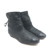 Chanel cap-toe perforated leather flat ankle boots in black, authentic pre-owned