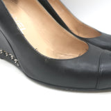 Chanel CC cap-toe wedge pumps in black leather with chain trim, pre-owned luxury heels with light wear