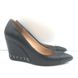 Chanel black leather wedge pumps with CC cap toe and chain trim, authentic pre-owned, size 35.5