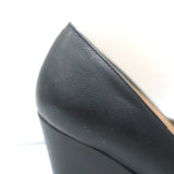 Chanel chain-trimmed cap-toe wedge pumps in black leather, authentic pre-owned luxury with visible wear.