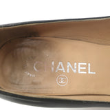 Chanel chain-trimmed wedge pumps in black leather with CC cap toe, pre-owned with authentic luxury wear.