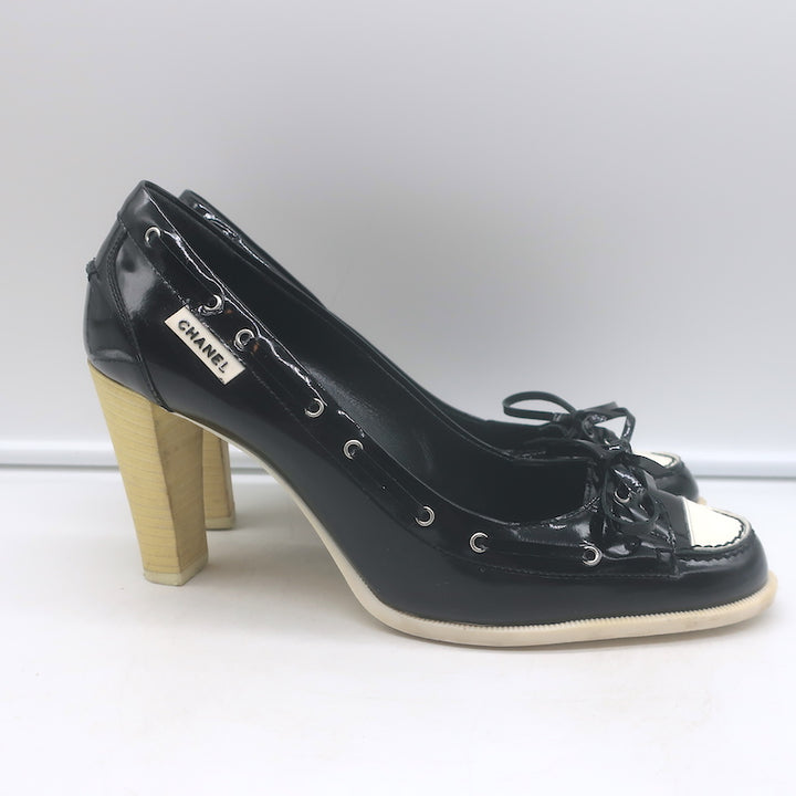 Chanel 06P bow cap-toe pumps in black-and-white patent leather, authentic pre-owned luxury.