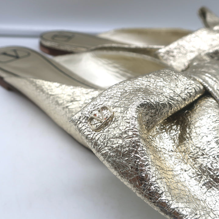 Valentino Unchateau bow mules in gold metallic cracked leather, pre-owned, luxury flat slip-on with signature bow (EU 38.5)
